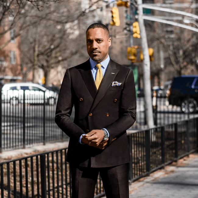 African man in a black lapel standing in a park Image